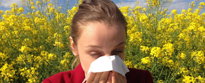 a woman with allergies sneezing
