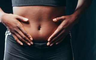 A woman holding her gut needing holistic parasite cleansing